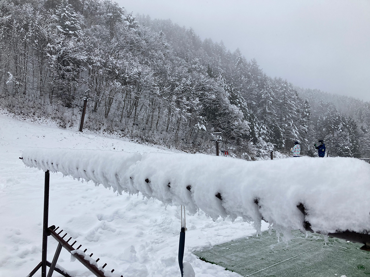 雪がこんもり積もったスキーラックと雪景色のゲレンデ